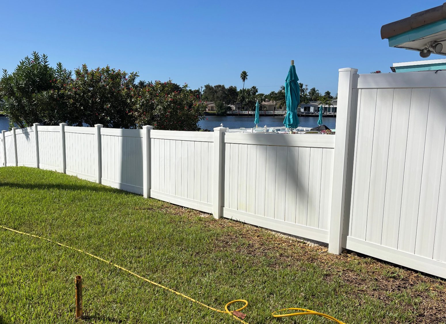 After our Rust Removal Clean Up service. What a difference! Photo of a backyard Vinyl fencing that has been professionally treated with a special formula of rust removal solution.